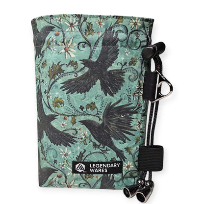 Legendary Wares Ravenflight dice bag with flying ravens and floral pattern on a teal background. Features drawstring closure.